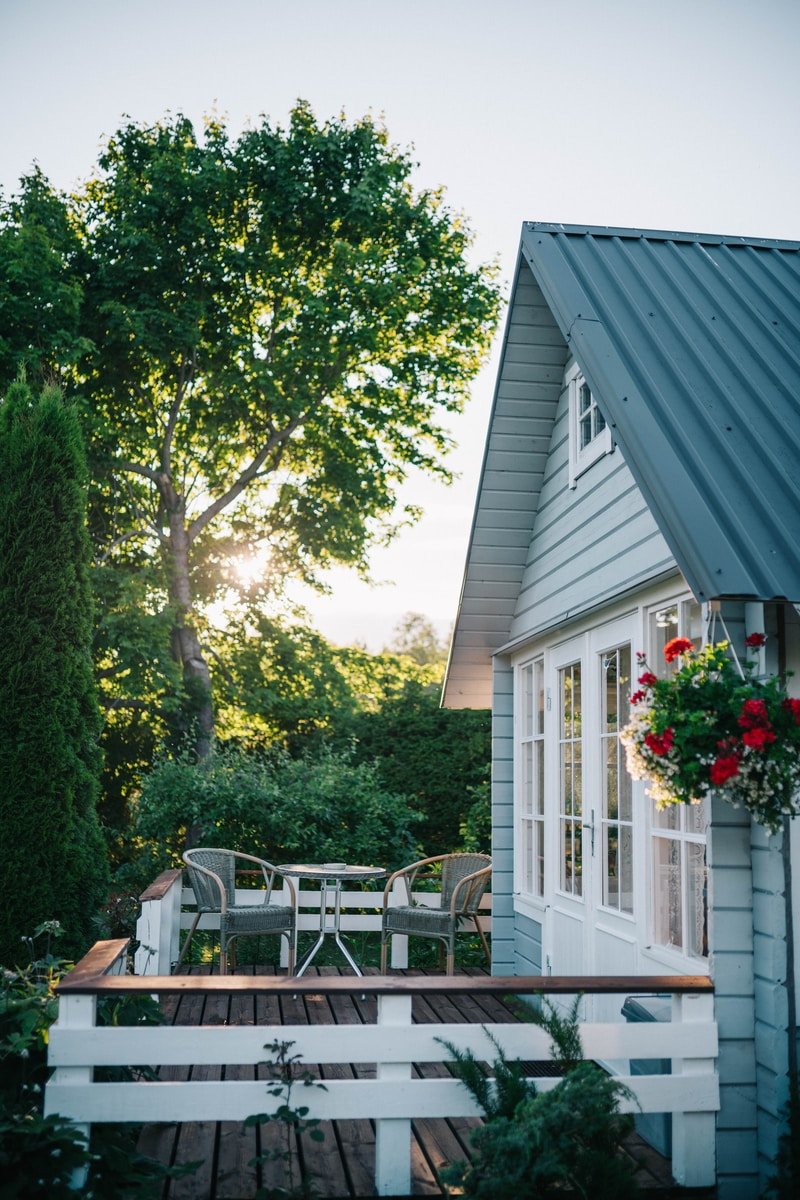 white wooden house near green trees during daytime